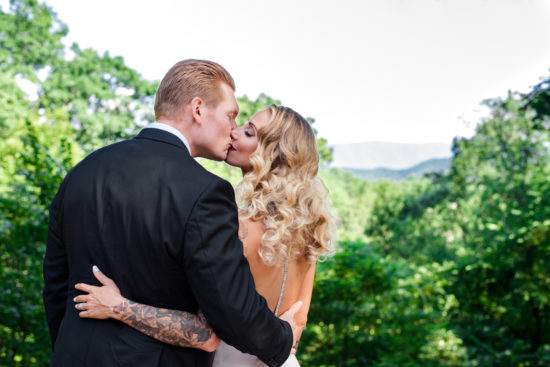 Bride and groom kissing in a wedding portrait by The Modern Heart. The bride is wearing makeup from Aesthetics by Hannah.